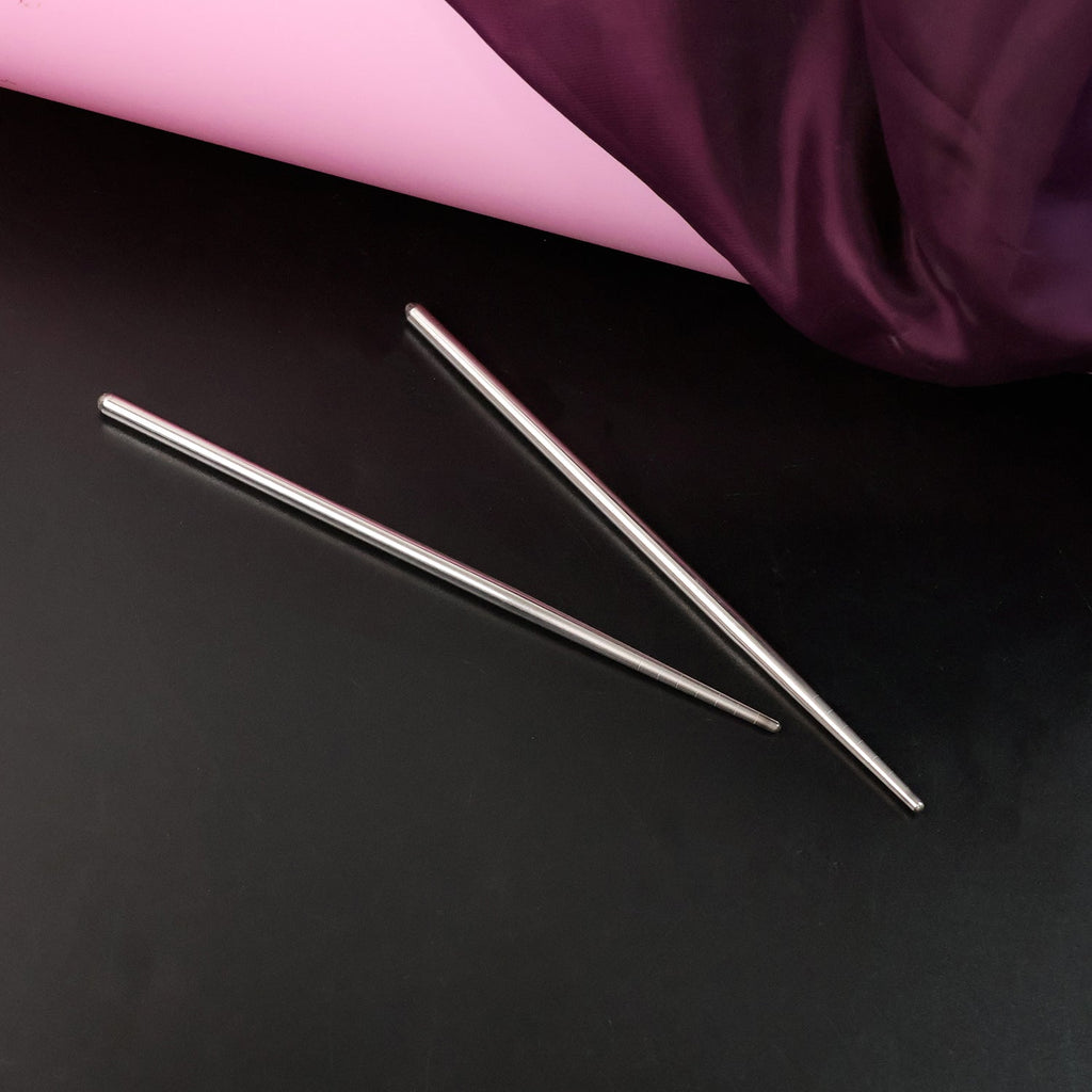 Stainless steel chopsticks elegantly holding food during a meal.