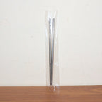 Stainless steel chopsticks actively used to pick up food during a meal.