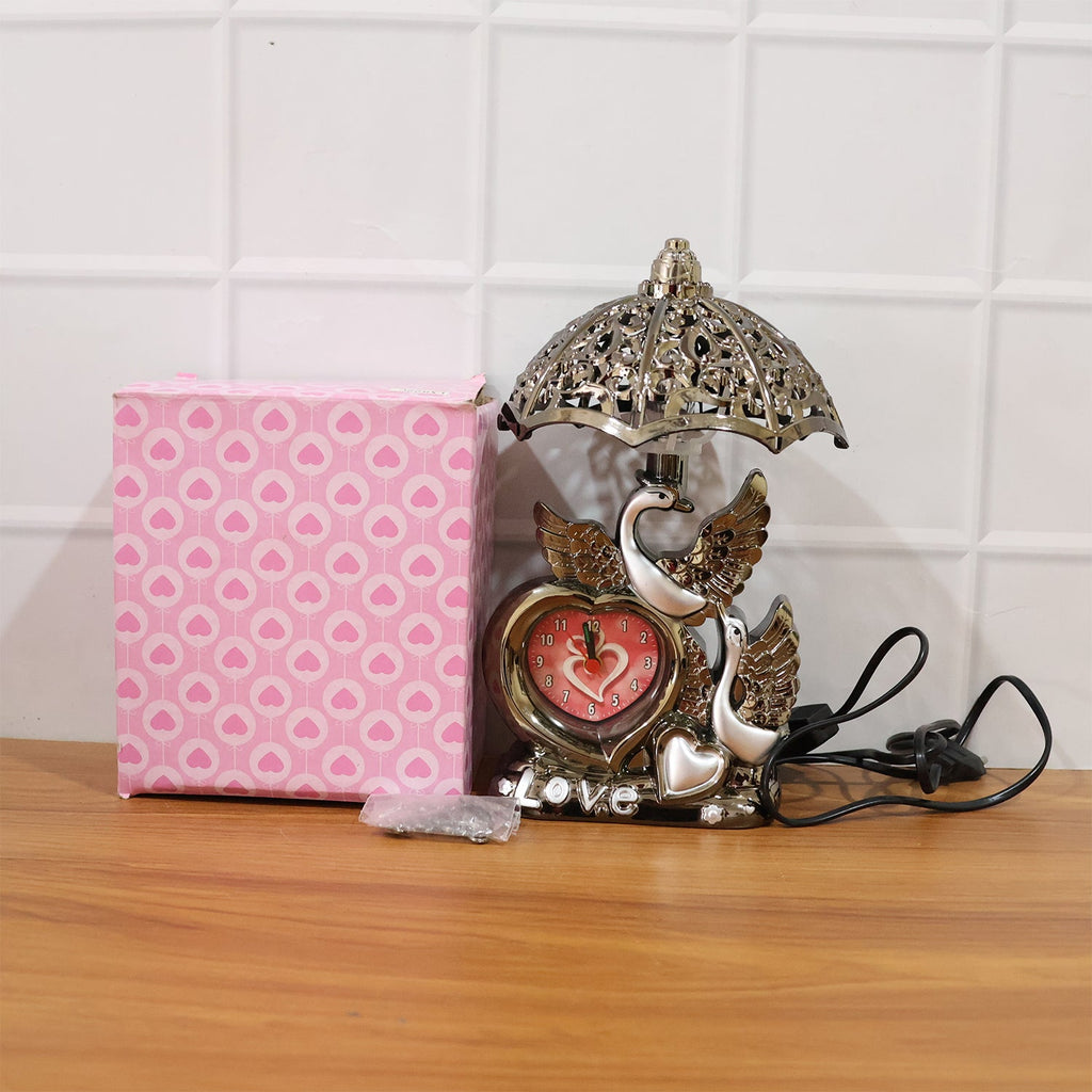 Decorative table lamp with swan couple and clock on living room table