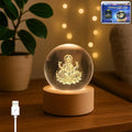 Front view of the glowing Ganpati 3D Crystal Ball Lamp on its elegant wooden base.
