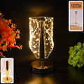 Crystal table lamp with golden leaf design on acrylic shade, showing stylish warm light