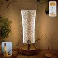 Crystal table lamp with sparkle acrylic shade and golden base illuminating softly