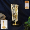 Crystal table lamp with cylindrical crystal-cut shade and golden base