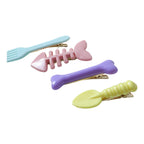 Four different cartoon hair clips neatly arranged to add fun to any hairstyle.