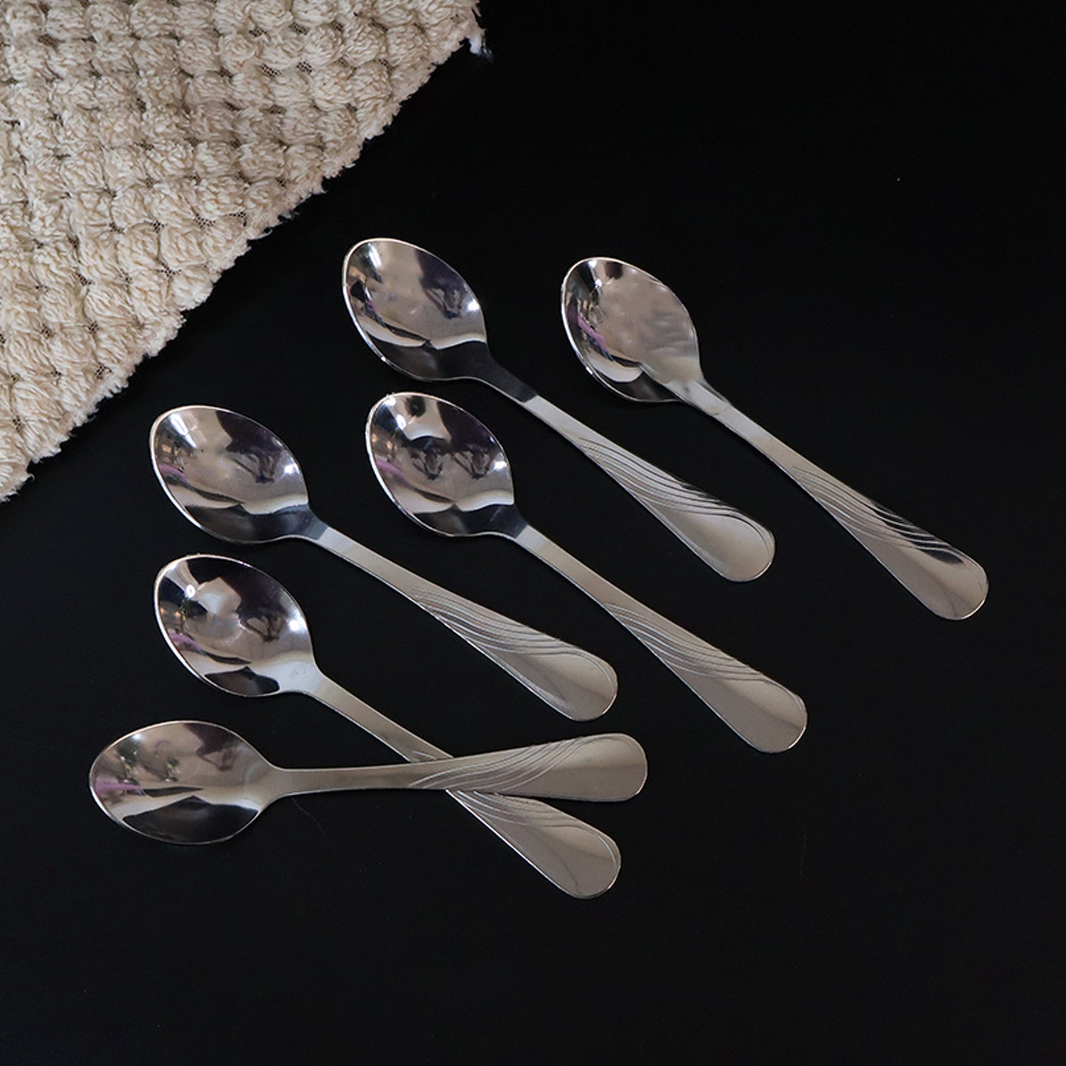 Single polished stainless steel dining spoon with mirror-like shine