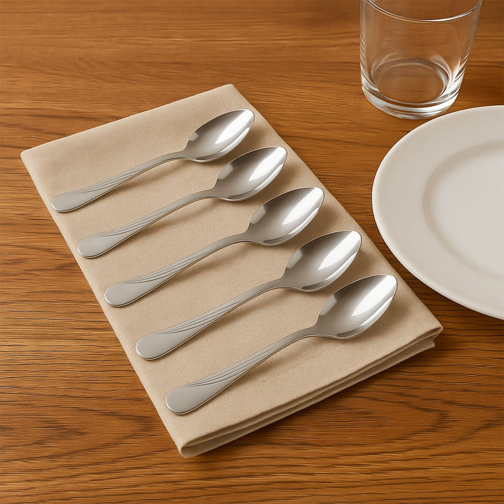 Close-up of elegant stainless steel dining spoons with engraved handles