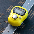 Digital finger tally counter held in hand for meditation and exercise counting