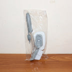 Soap-dispensing dish brush in action, cleaning food residue from a plate