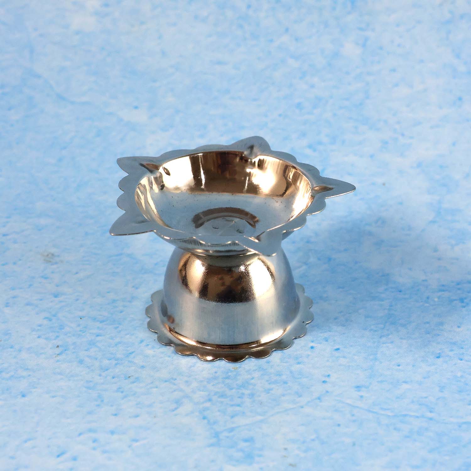 Close-up of metal sunflower design diya stand with durable finish