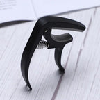 Guitar capo and pick holder positioned on a guitar neck, ready for playing.
