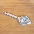 Stainless steel egg separator displayed with clean, shiny finish