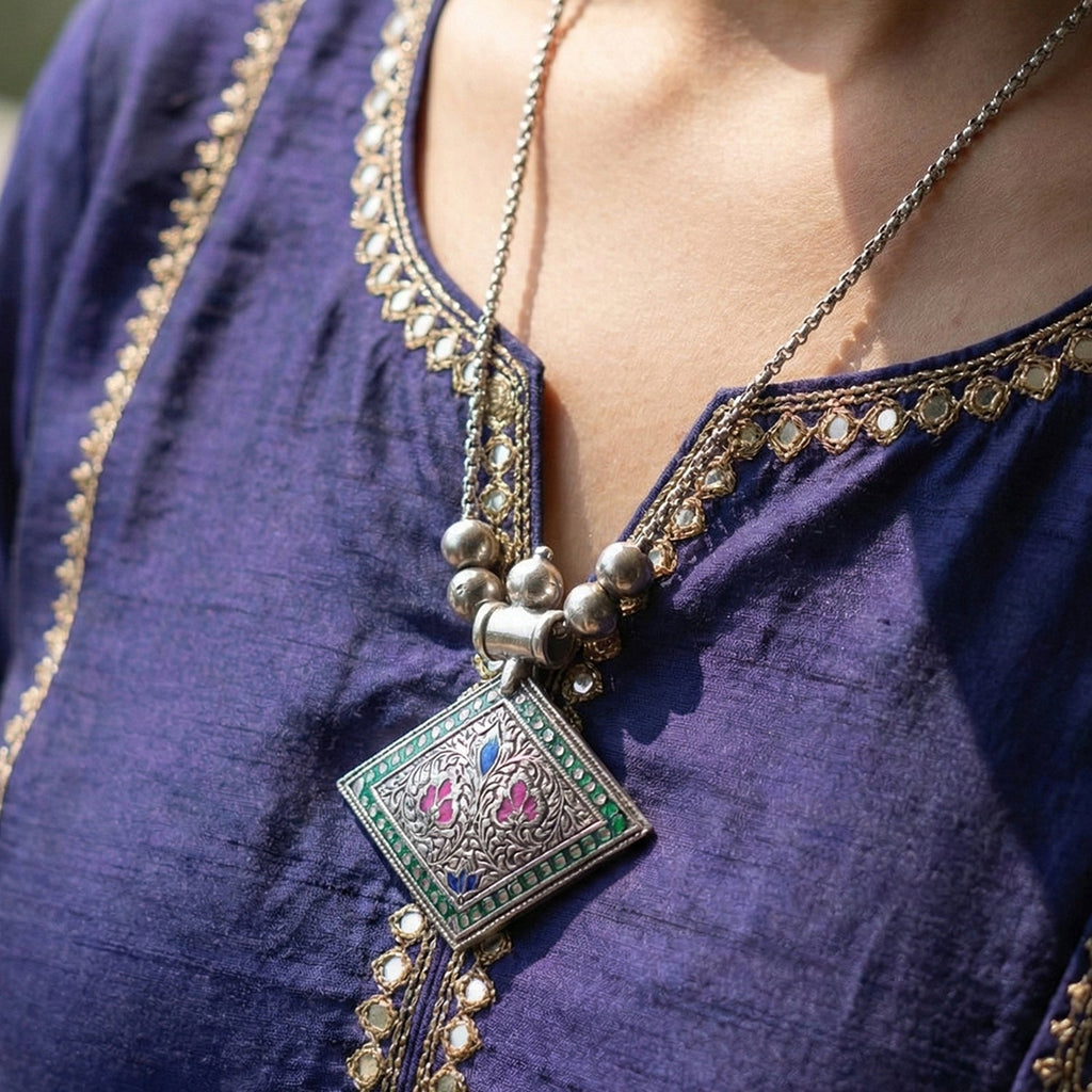 Close-up of oxidised silver square pendant with handcrafted floral designs