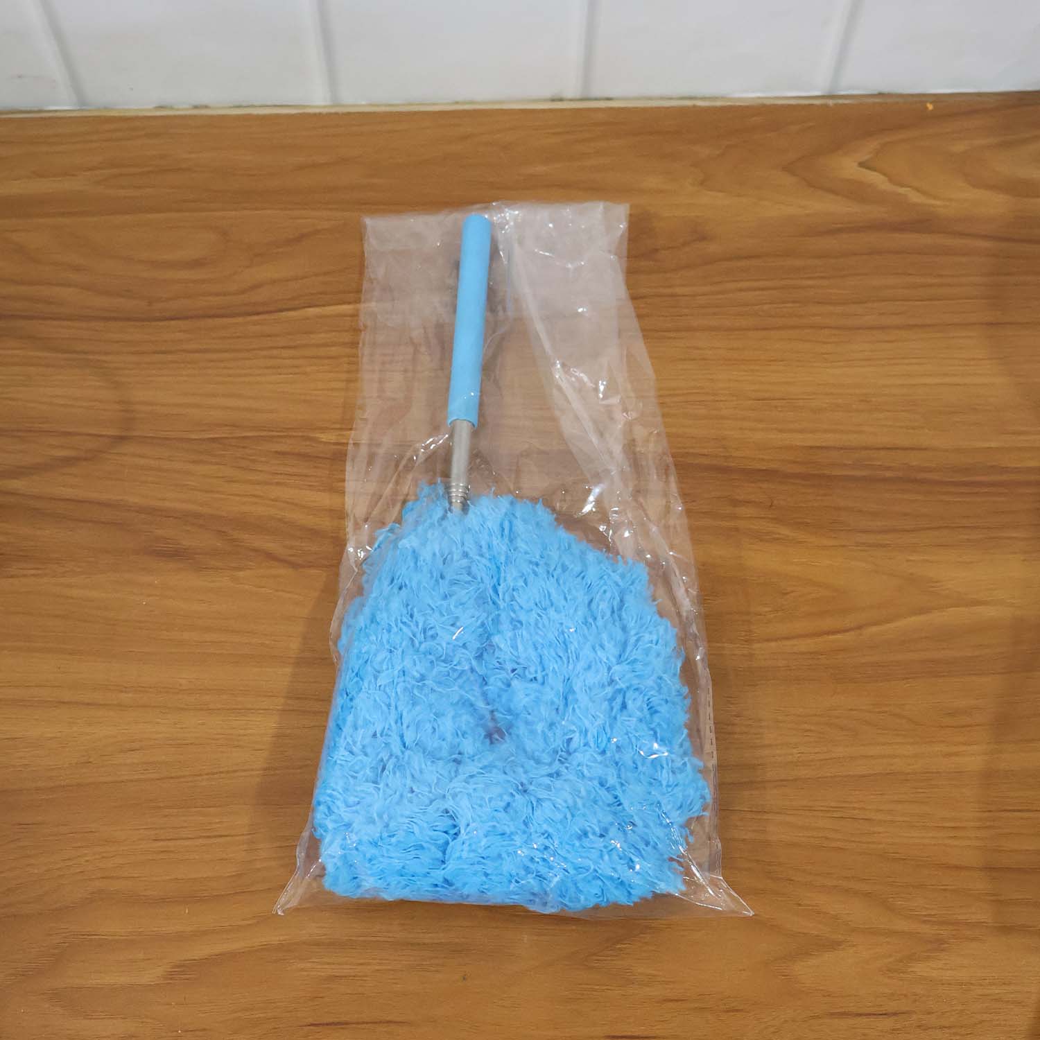 Extendable microfiber cleaning duster in action removing dust from ceiling vents
