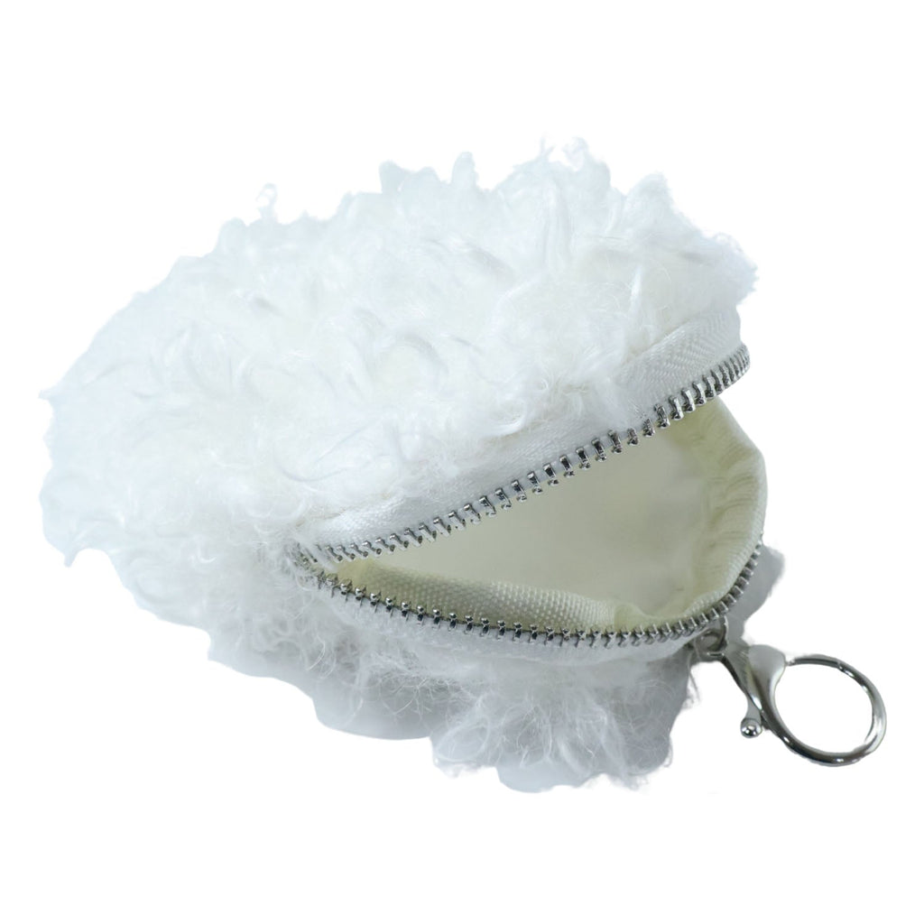 Lifestyle image of fluffy coin pouch attached to bag