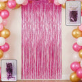 Shiny foil fringe curtain hanging from a doorway creating a metallic shimmer party backdrop.