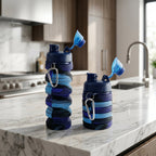 Folded collapsible water bottle placed beside a backpack for travel use