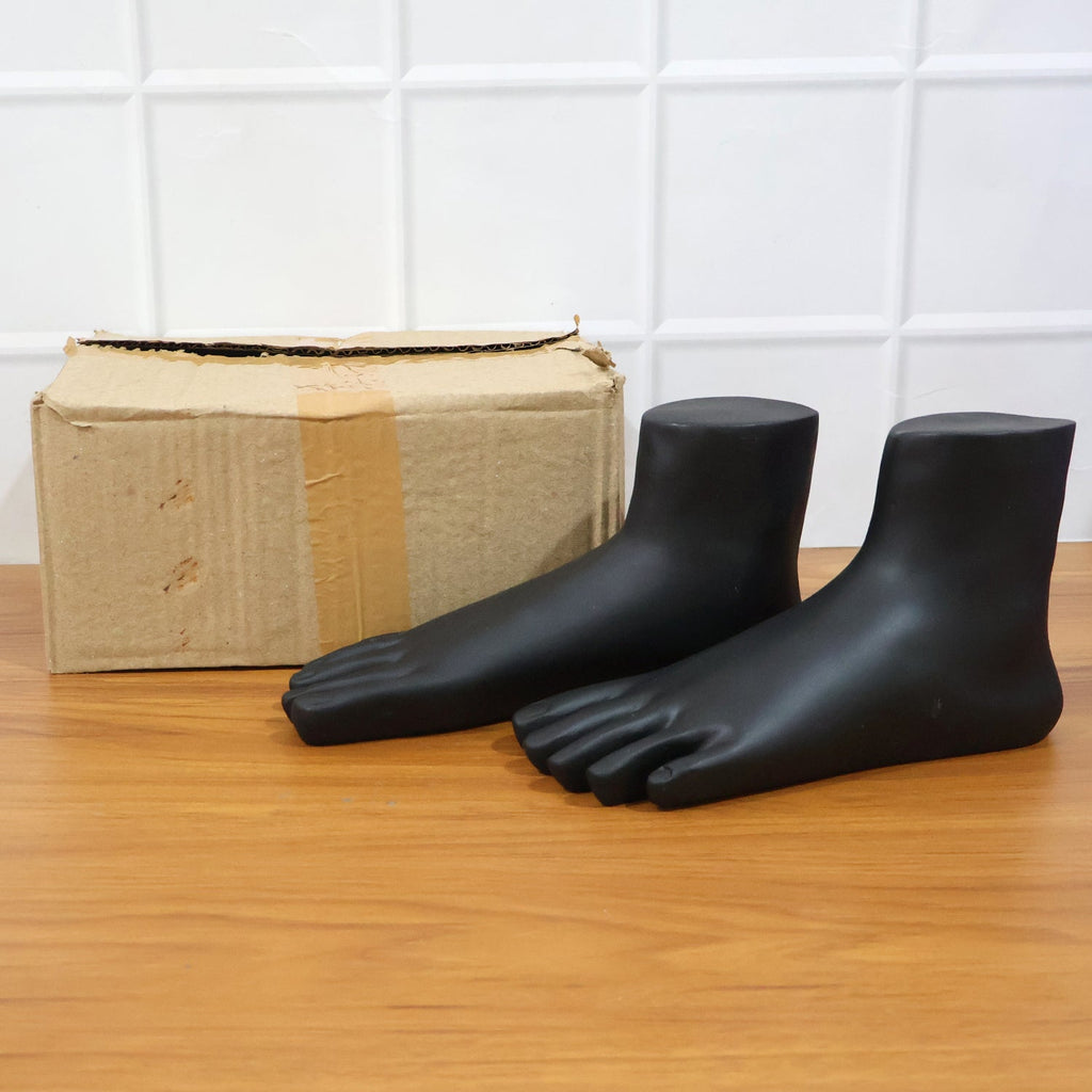 Top view of black foot mannequin display stand pair emphasizing matte finish and shape