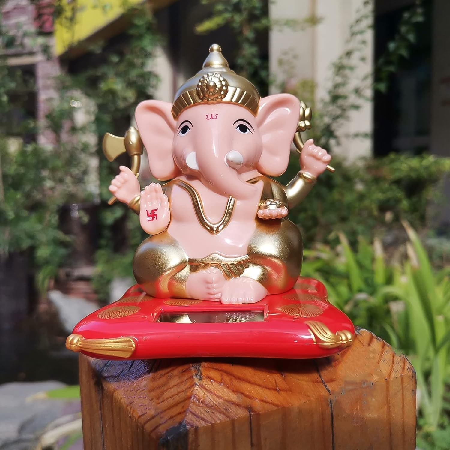 Lord Ganesha solar idol with gold tone highlights on a red and gold base