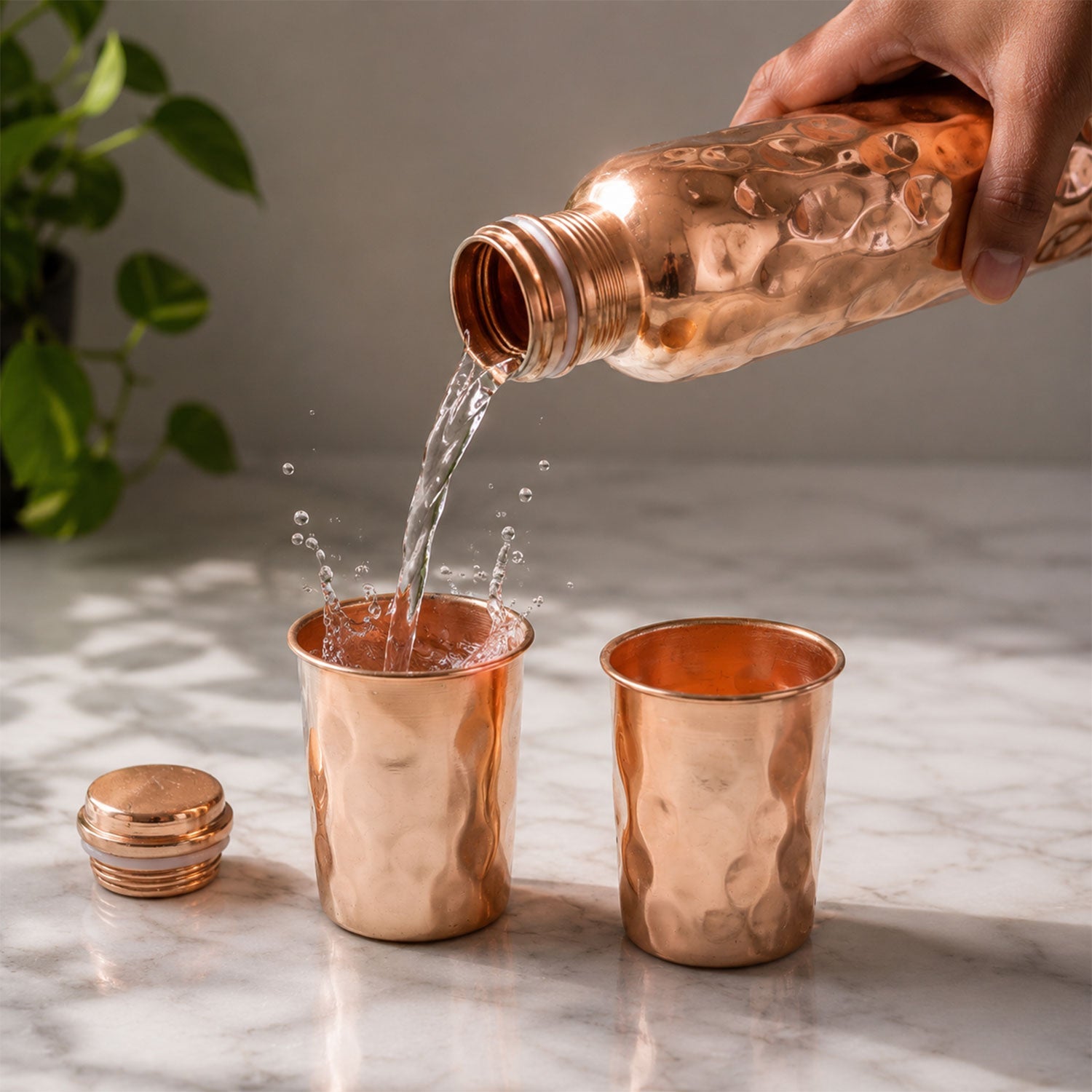 Front view of the diamond cut copper bottle and glasses, highlighting their reflective surface.