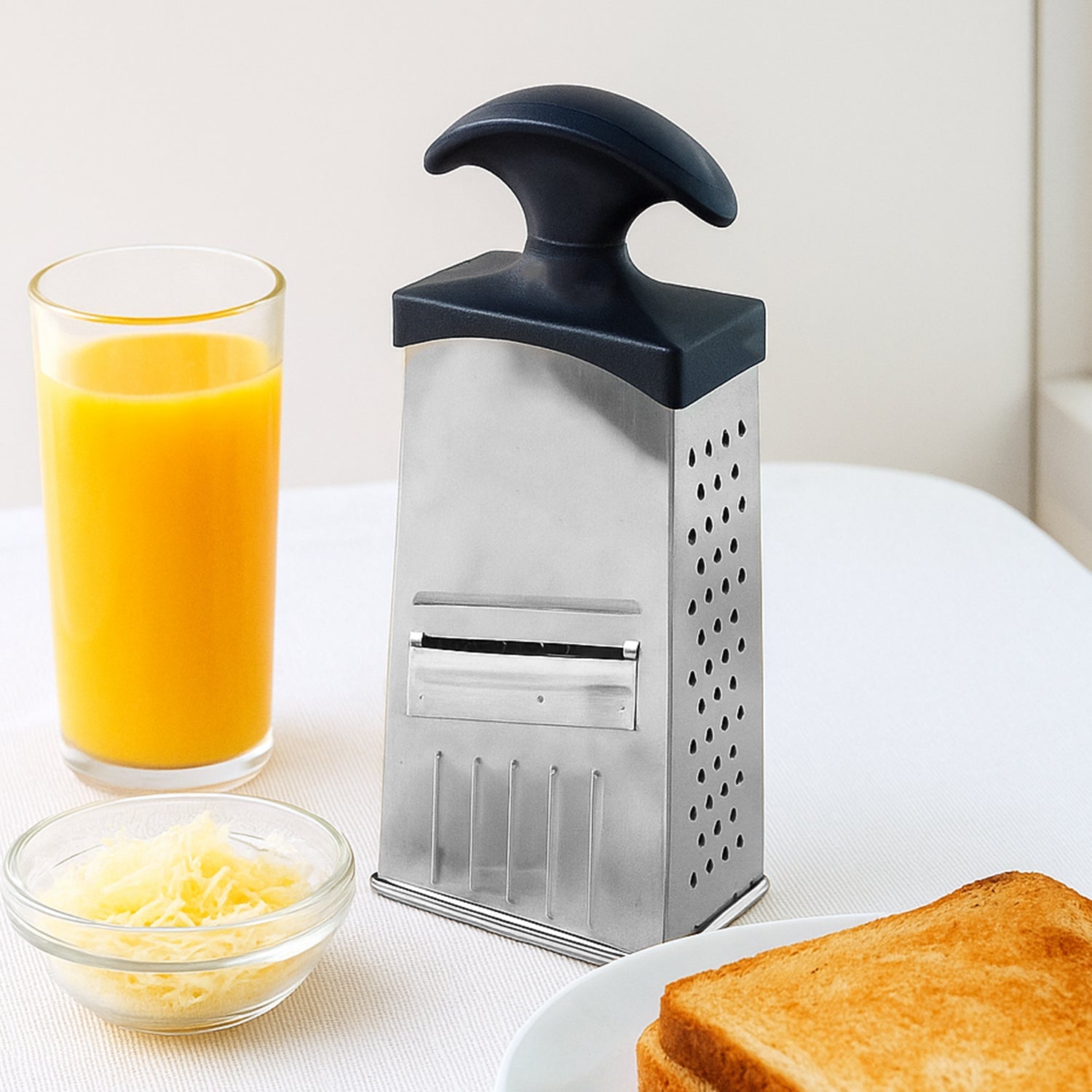Stainless steel 4-in-1 grater and slicer with ergonomic handle for kitchen use