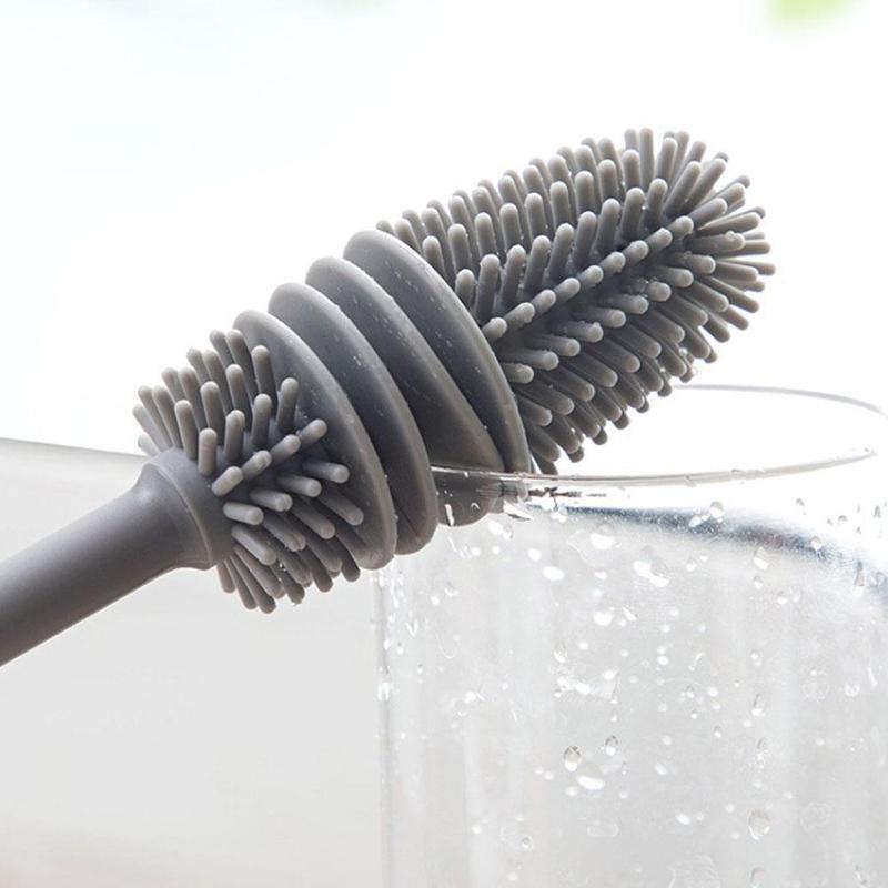 Hand holding a bottle cleaning brush, demonstrating its comfortable grip.