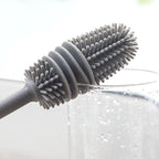 Hand holding a bottle cleaning brush, demonstrating its comfortable grip.
