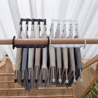 Organivo space-saving hanger with adjustable arms, demonstrating ease of use for trousers.