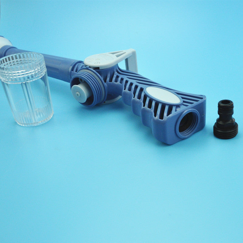 Water spray gun shown in a lush green garden setting, ready for use.