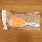 Overhead view of the Soft Cushion Hair Brush, showing flexible bristles and cushioned base.