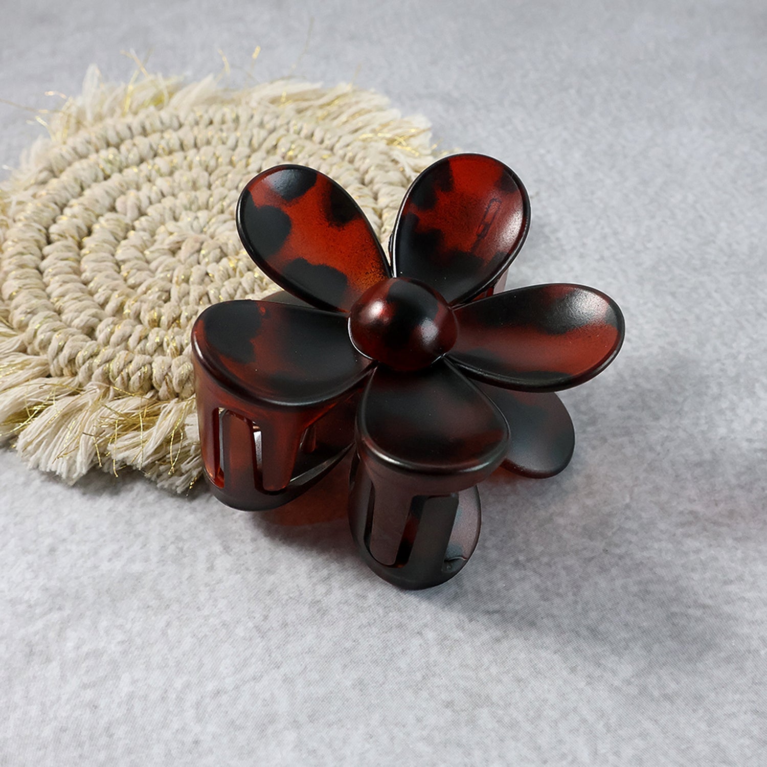 Plastic flower hair clip angled to show clasp and grip