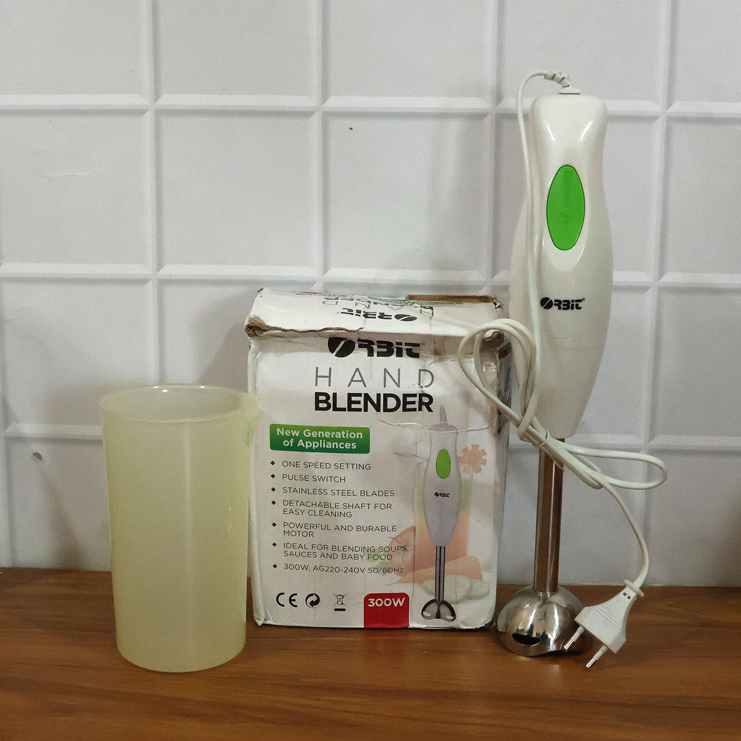 Electric hand blender in kitchen setting blending fresh ingredients