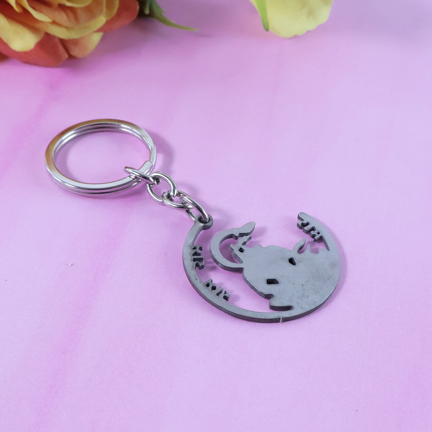 Devotional Jai Shri Ram Keychain with keys on a textured wooden surface.