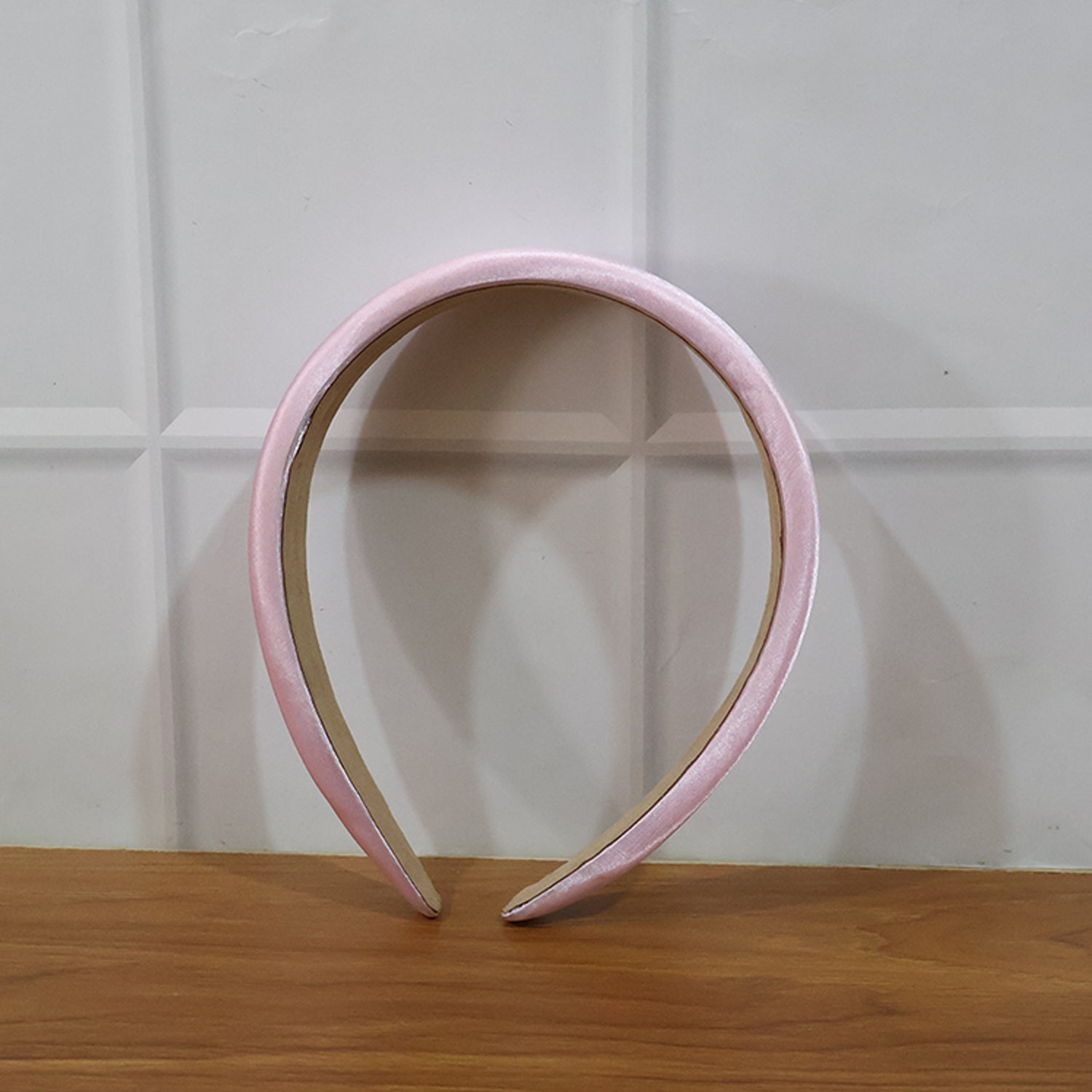 Padded satin hairband resting on a white surface showcasing elegance