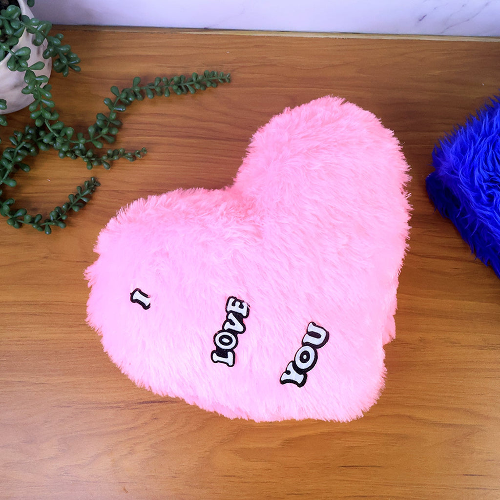 Cozy heart shape plush pillow displayed on a sofa