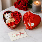 Side view of heart shaped gift box with teddy bear and rose arrangement