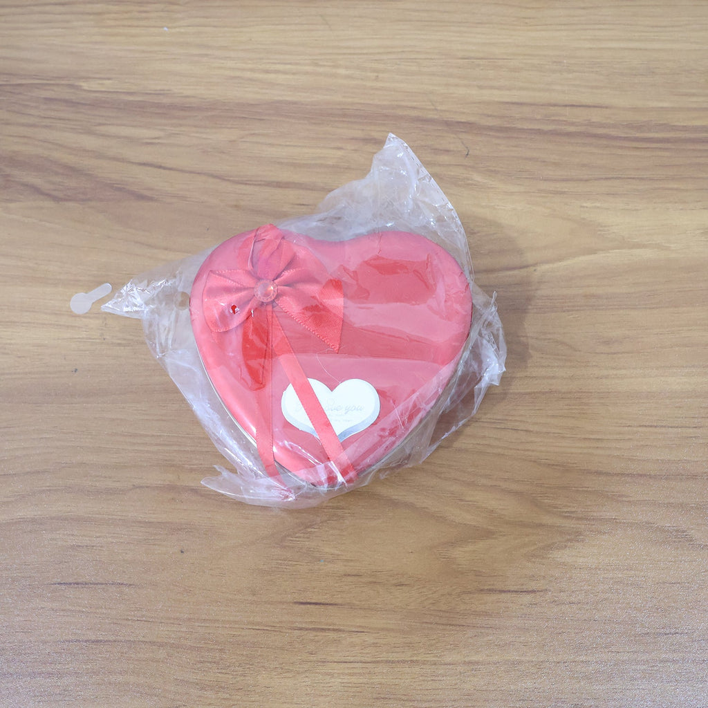 Live shot of heart shaped gift box featuring teddy bear and artificial roses