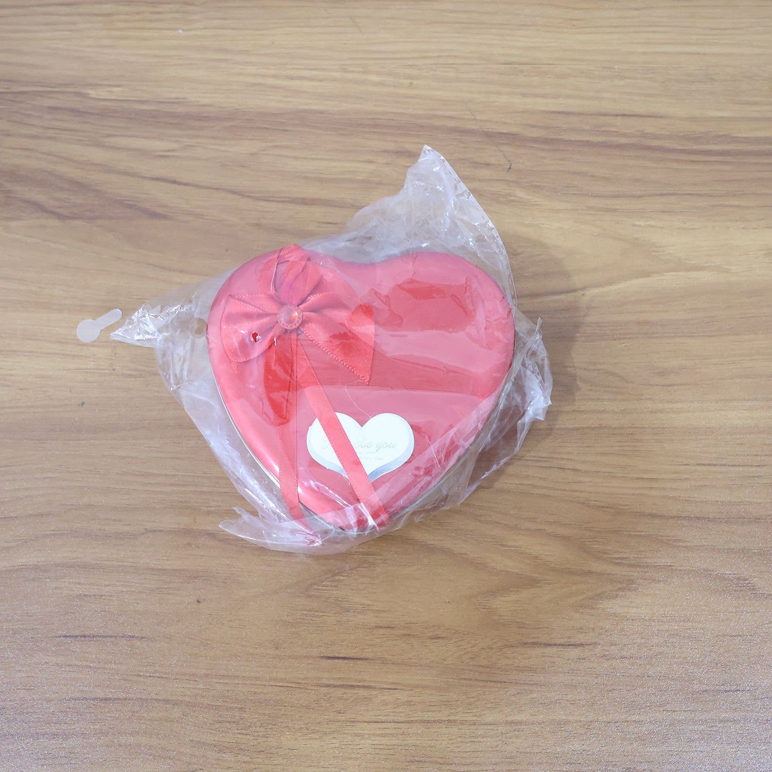 Live shot of heart shaped gift box featuring teddy bear and artificial roses