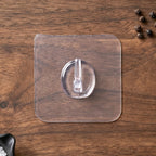 Self-adhesive clear wall hook in use for organizing small items