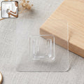 Self-adhesive transparent wall hook on a white background.