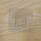 Pack of multiple transparent self-adhesive wall hooks.