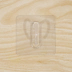 Close-up of transparent wall hook showing its adhesive pad