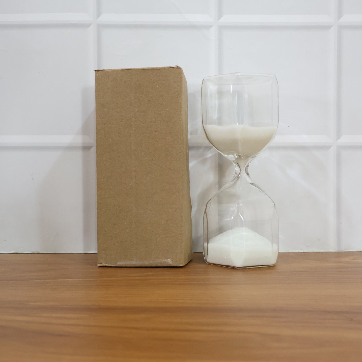 Glass sand timer hourglass shown in lifestyle setting as a desk and home décor accent