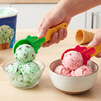 Two plastic ice cream scoops with colorful green and red handles, ready for serving.
