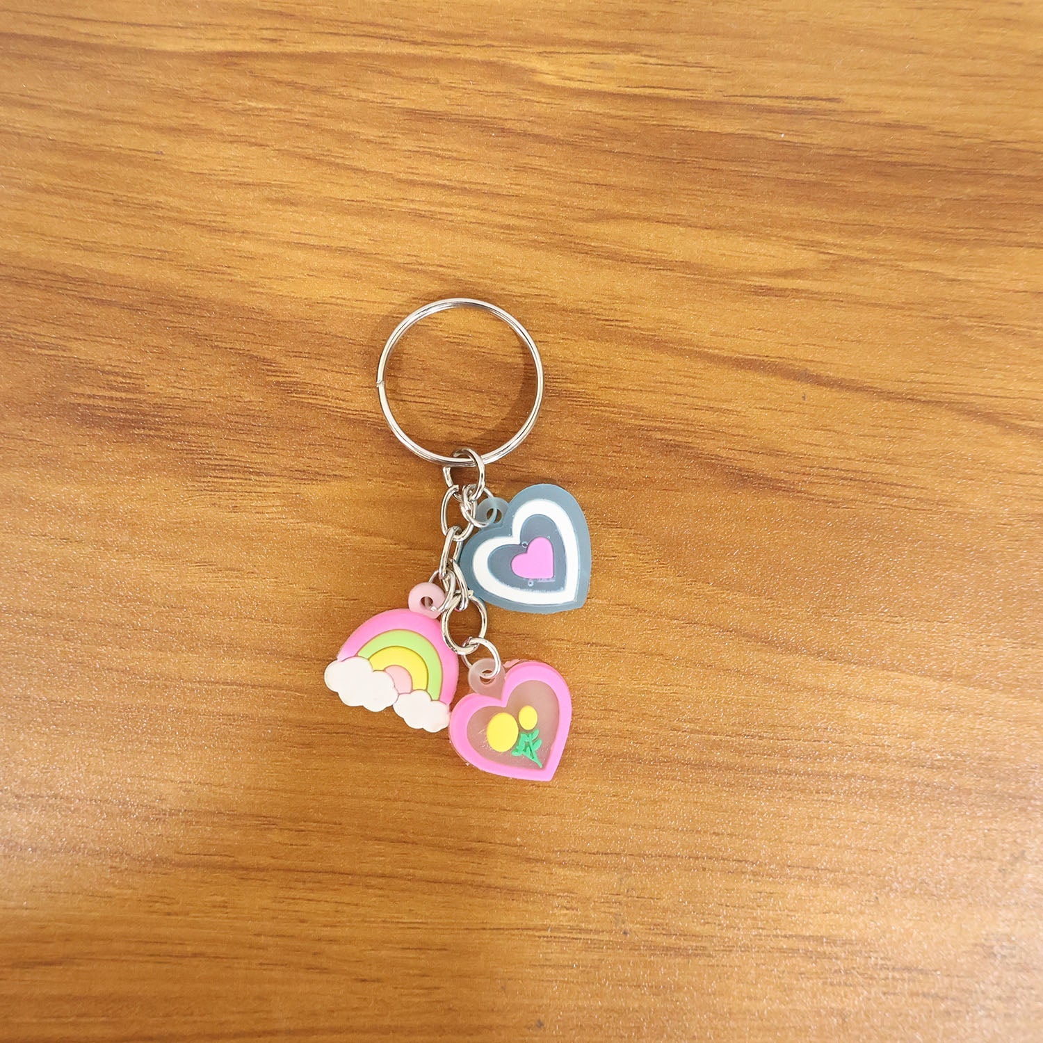 Heart and rainbow charm keychain fastened on a handbag