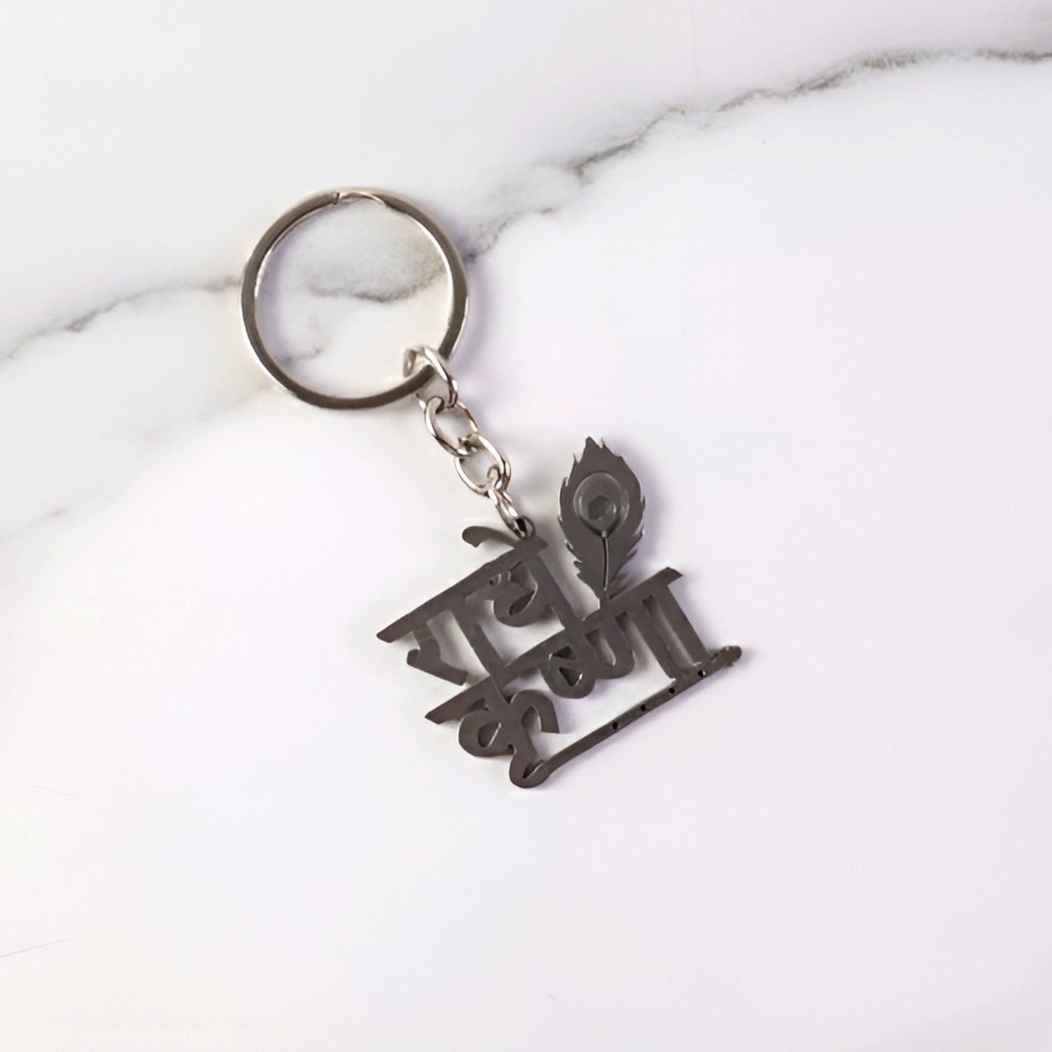 Key pendant attached to Radhe Krishna metal keychain highlighting craftsmanship