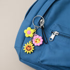 Decorative key holder featuring flower and smiley face charms