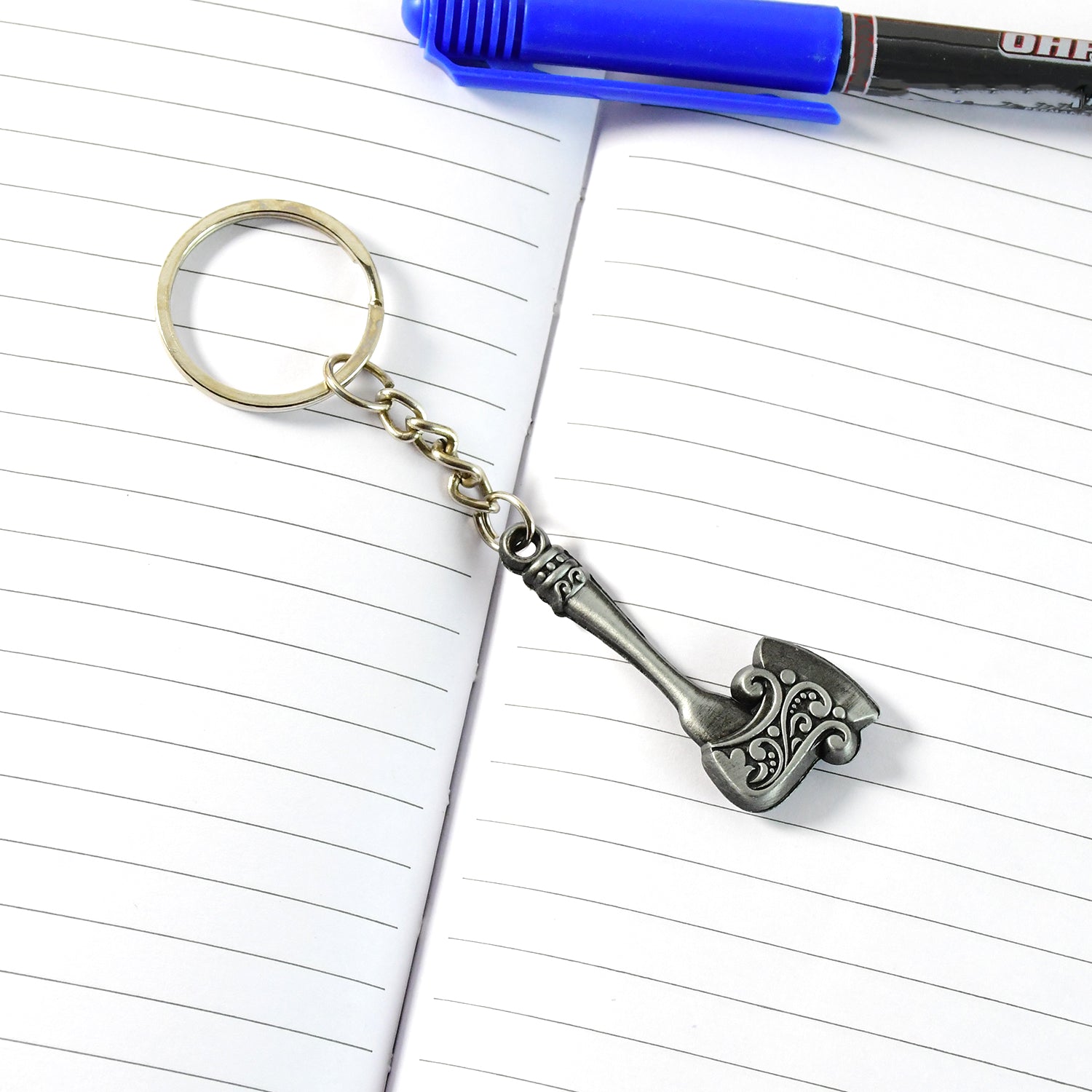 Metal keychain shaped like an axe shown against a neutral background