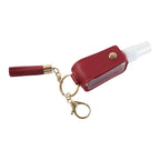 Hand sanitizer holder keychain clipped to handbag strap for easy access