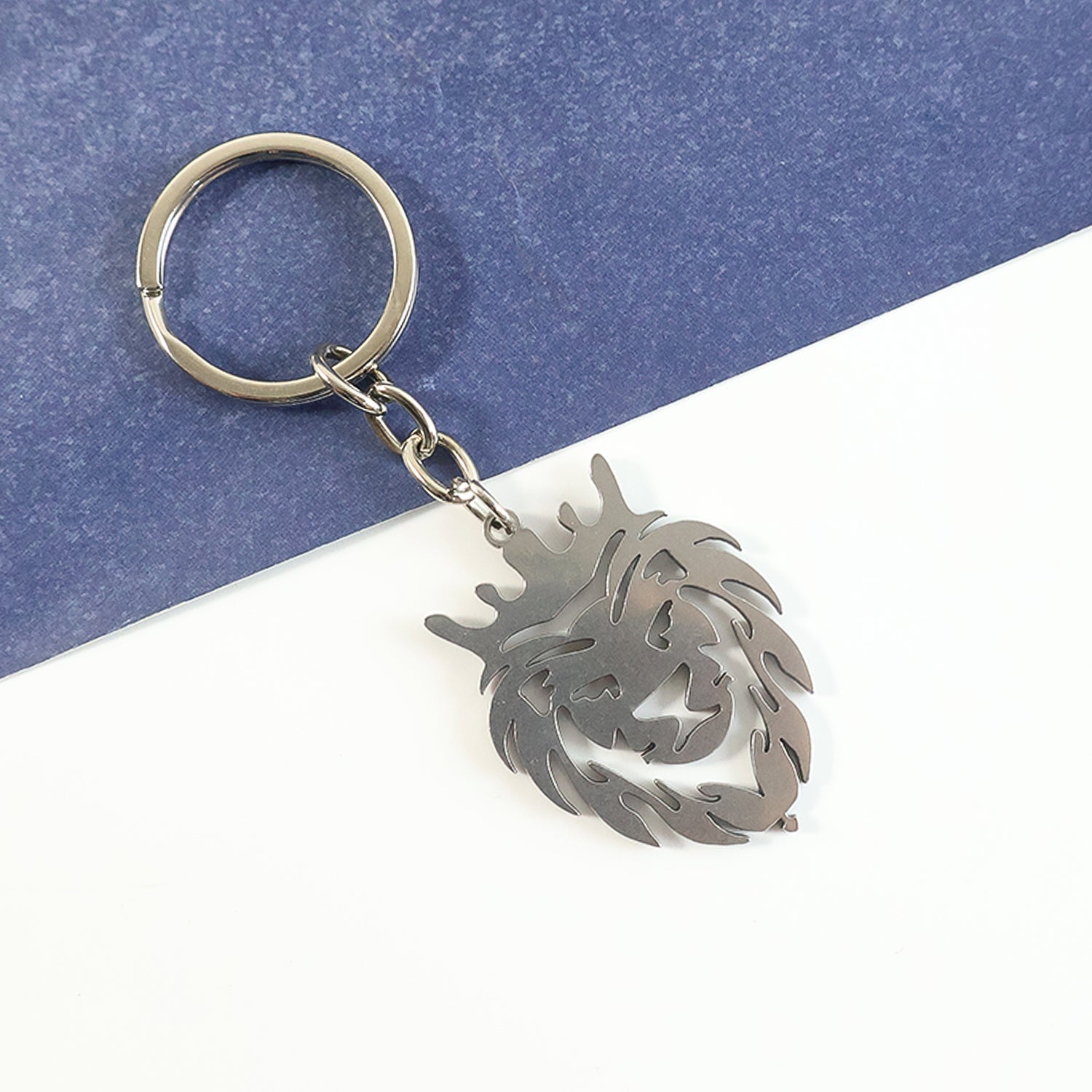 Close-up detail of a stainless steel lion head keychain showcasing the crown