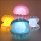 The Pearl Shell Night Lamp lit up, providing a comforting glow in a cozy setting.